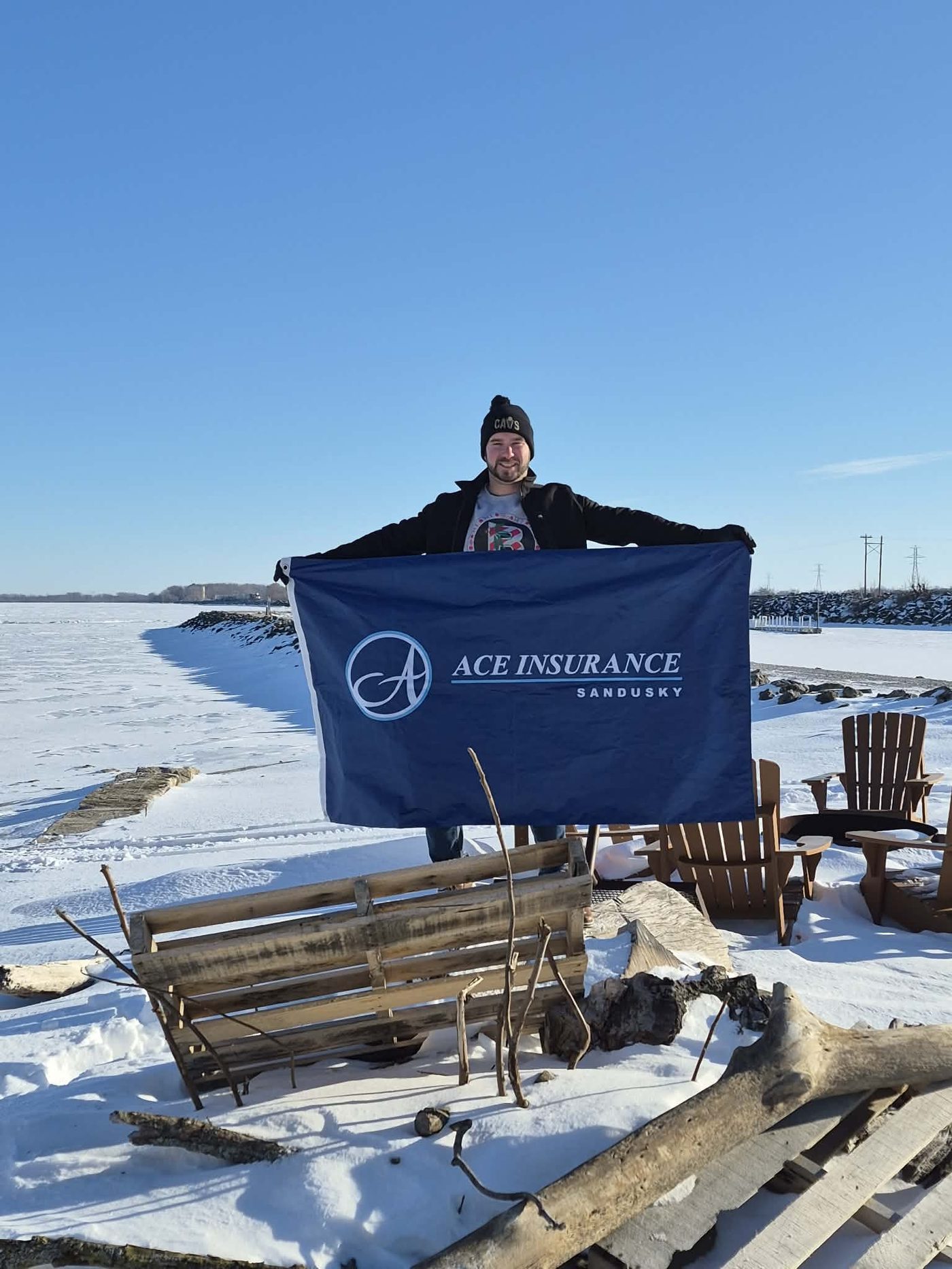 William Perry holding Ace Insurance flag on frozen Lake Erie