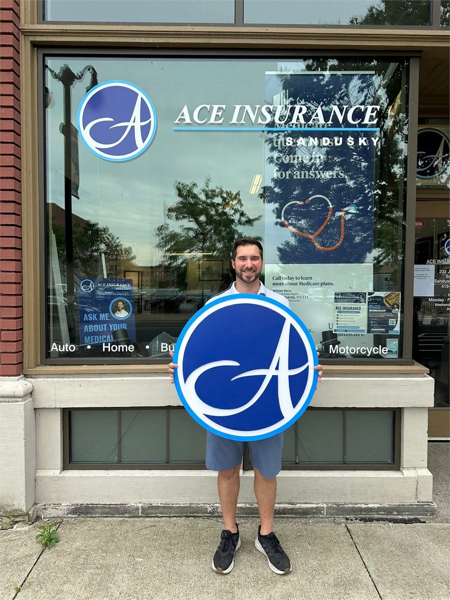 William Perry holding the Ace Insurance sign outside the Jackson Street office
